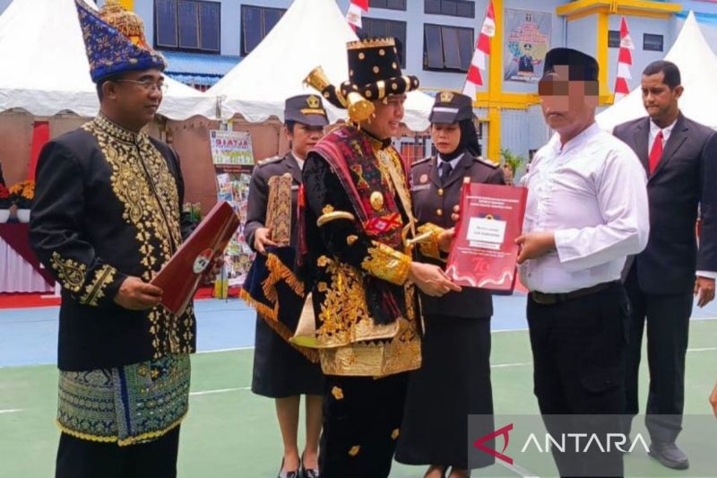 Pj Gubernur Sumut Agus Fatoni (tengah) didampingi Kepala Kanwil Kemenkumham Sumatera Utara Anak Agung Gde Krisna (kiri) menyerahkan remisi, di Lembaga Pemasyarakatan Khusus Anak Kelas II Medan, Sabtu (17/8/2024). (ANTARA/Aris Rinaldi Nasution)