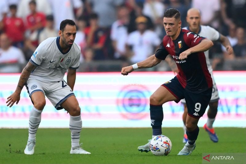 Gelandang Genoa Vitinha (kanan) berduel memperebutkan bola dengan gelandang Inter Milan? Hakan Calhanoglu pada pertandingan Liga Italia 2024/2025 di Stadion Luigi Ferraris, Genoa, Sabtu (17/8/2024). (ANTARA/AFP/MARCO BERTORELLO)