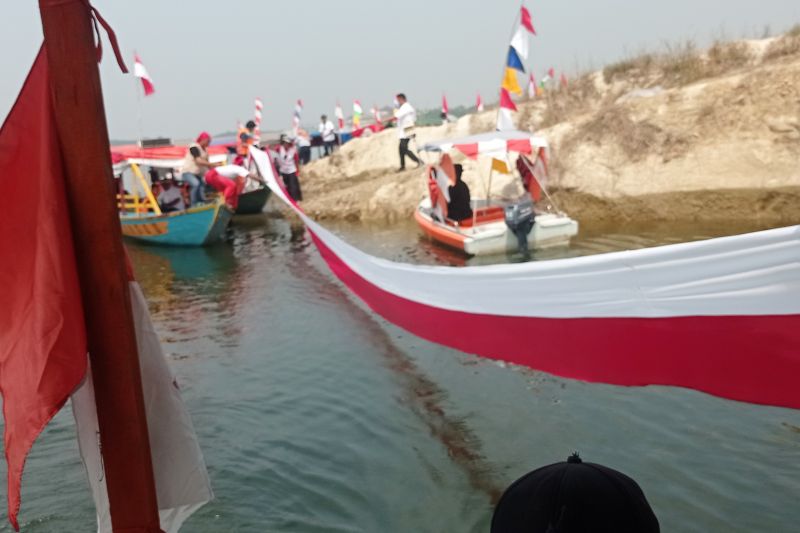 Masyarakat Desa Pasir Tanjung Rangkasbitung Kabupaten Lebak membentangkan bendera merah putih sepanjang 500 meter sambil bermain keliling menggunakan perahu di atas Bendungan Karian.ANTARA/Mansur