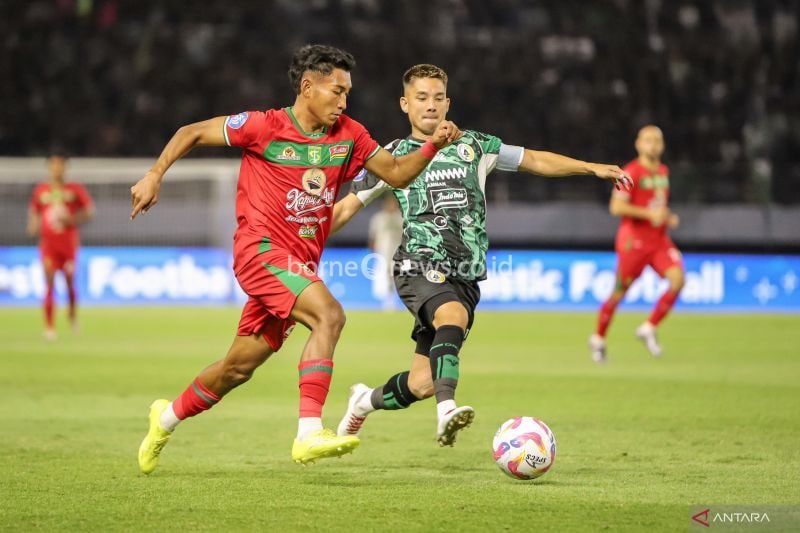 Kapten tim PSS Sleman Kim Jeffrey Kurniawan (kanan) berebut bola dengan pemain Persebaya Alfan Suaib (kiri) saat pertandingan pekan pertama BRI Liga 1 Indonesia musim 2024/2025 di Stadion GBT Surabaya, Minggu (11/8/2024) malam. (ANTARA FOTO/Rizal Hanafi)