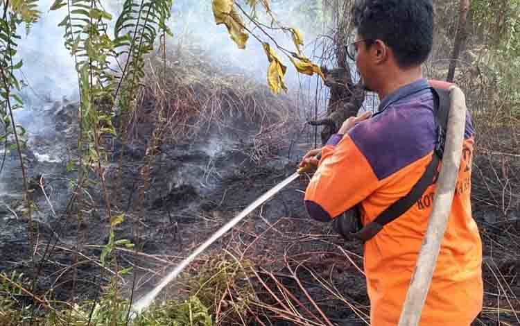 Anggota TRC BPBD Palangka Raya saat melakukan pendinginan lahan di lokasi Karhutla Jalan Donis Tuan. (Foto : TRC BPBD Palangka Raya)
