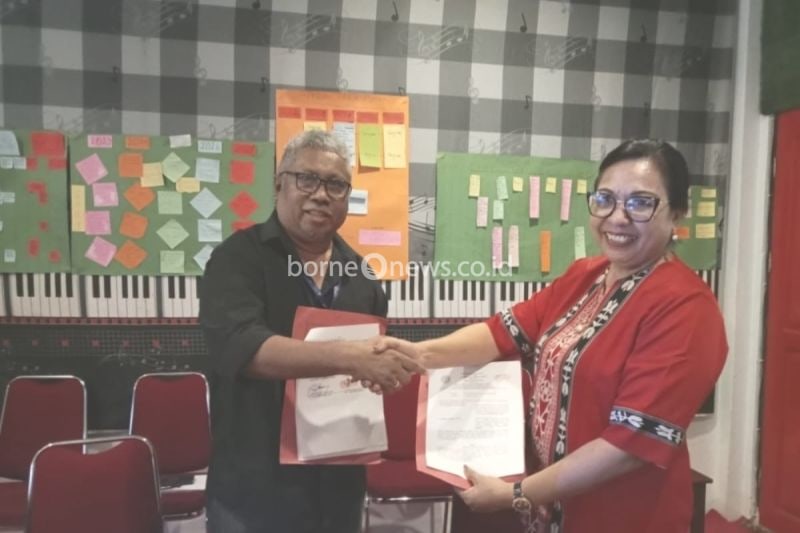 Direktur Ambon Music Office (AMO) Rony Loppies (kanan), dan Kepala Sekolah SMA YPKPM Ambon, E. Laturiuw (kiri) melakukan penandatangan kerjasama implementasi kurikulum muatan lokal musik tradisional tingkat SMA, Selasa (20/8). ANTARA/HO- Ambon Music Office.
