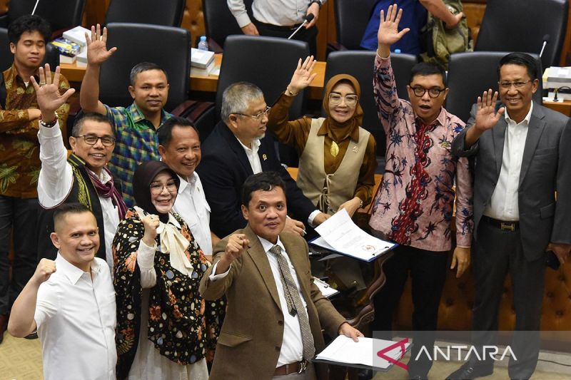 Menteri Hukum dan HAM Supratman Andi Agtas (kanan) dan Menteri Dalam Negeri Tito Karnavian (keempat kanan), bersama Wakil Ketua Badan Legislasi DPR yang juga pimpinan rapat Achmad Baidowi (kedua kanan), dan perwakilan fraksi yang menyetujui RUU melambaikan tangan usai menandatangani naksah persetujuan RUU Pilkada dalam rapat pengambilan keputusan pembahasan RUU Pilkada antara Baleg DPR dengan Pemerintah di Kompleks Parlemen, Senayan, Jakarta, Rabu (21/8/2024). Badan Legislasi DPR mengesahkan Rev