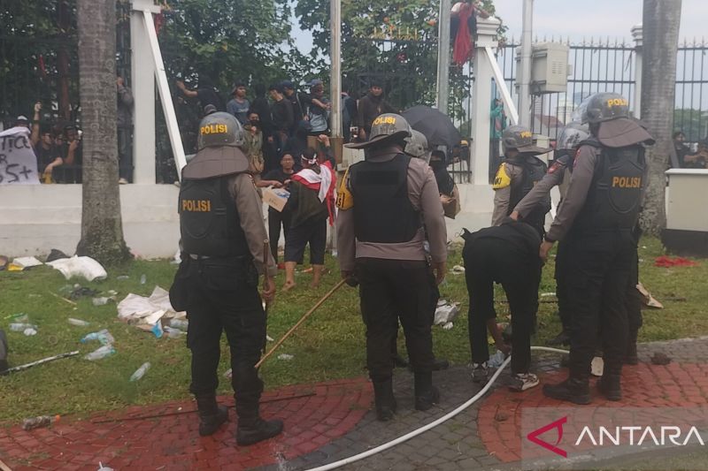 Polisi membiarkan satu orang demonstran untuk mengambil air di halaman depan gedung DPR RI, Kamis (22/8/2024) (ANTARA/Walda Marison)