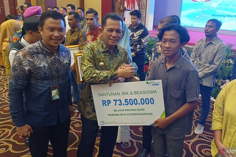 Kepala BPJS Ketenagakerjaan Tanjungpinang Sunjana Ahmad mendampingi Gubernur Kepri Ansar Ahmad menyerahkan dana santunan secara simbolis kepada ahli waris nelayan di Aula Wan Seri Beni Dompak, Tanjungpinang, Kamis (22/8/2024). (ANTARA/Ogen)