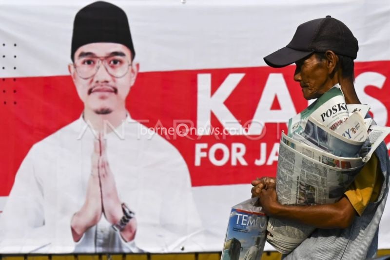 Penjual koran melintas di depan alat peraga sosialisasi bergambar Ketua Umum PSI Kaesang Pangarep di Pancoran, Jakarta, Senin (12/8/2024). ANTARA Foto/Muhammad Ramdan/aww.
