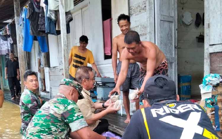 Pj Bupati Gunung Mas Naik Perahu Serahkan Bantuan Makanan kepada Korban Banjir di Tewah