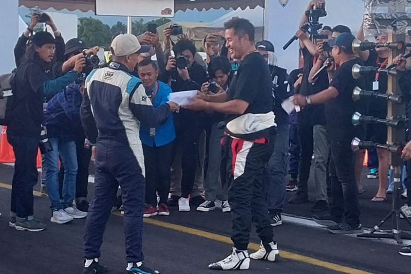 Wakil Ketua Umum Mobilitas Ikatan Motor Indonesia (IMI) Pusat Rifat Sungkar (kanan) menyerahkan hadiah kepada pembalap yang memenangi tantangan mengalahkan dirinya saat mengadu kecepatan waktu pada ajang Pertamax Turbo Drag Fest 2024 di Pangkalan Udara Wiriadinata, Tasikmalaya, Jawa Barat, Sabtu (24/8/2024). (ANTARA/Aloysius Lewokeda)