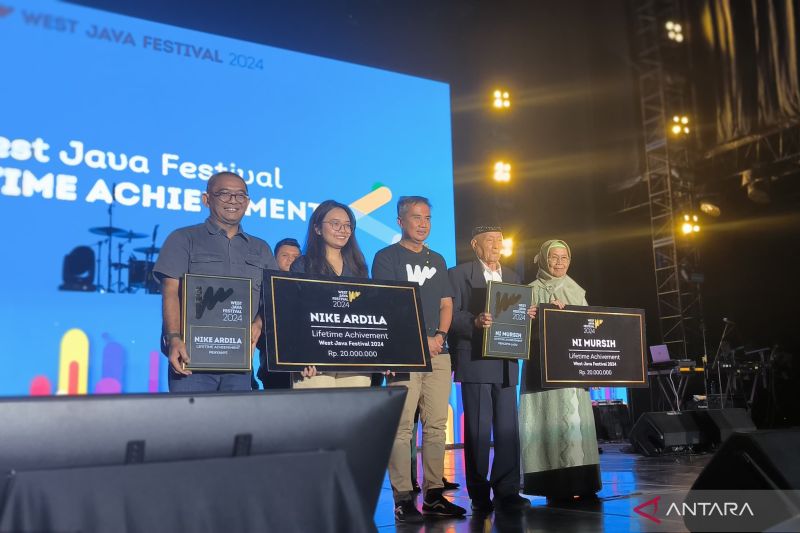 Endang Hidayat (anak pencipta lagu Es Lilin Ni Mursih) dan Alan Yudi (kakak Nike Ardilla) menerima penghargaan Lifetime Achievement dari Pemprov Jabar yang diberikan langsung oleh Pj Gubernur Jabar Bey Triadi Machmudin, Lapangan Saparua, Bandung, Minggu (25/8/2024). (ANTARA/Ricky Prayoga)