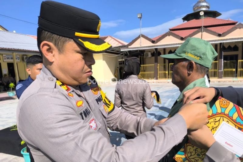 Kapolres Majene Ajun Komisaris Besar Polisi Toni Sugadri (kiri) menyematkan pita tanda operasi kepada salah seorang linmas pada apel gelar pasukan Operasi Mantap Praja pengamanan Pilkada Serentak 2024, Senin (26/8). (ANTARA/HO/Humas Polres Majene)