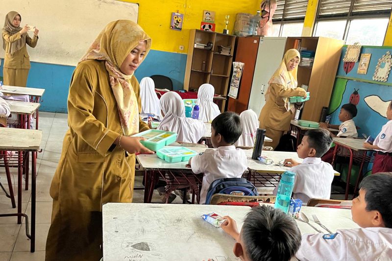 Guru di Sekolah Dasar Negeri (SDN) Rawa Kompeni Kota Tangerang membagikan makan kepada siswa dalam program pembiasaan makan begrizi gratis, Senin. (ANTARA/HO-Pemkot Tangerang)