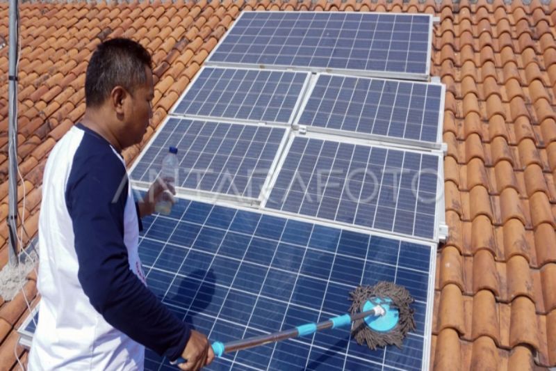 Ilustrasi- Seorang warga pemilik panel surya membersihkan panel Pembangkit Listrik Tenaga Surya (PLTS) di atap rumahnya. (ANTARA FOTO/Harviyan Perdana Putra/foc.)