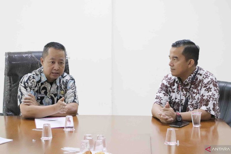 Kepala Dinas Komunikasi, Informatika, Persandian, dan Statistik Kabupaten Bekasi Yan Yan Akhmad Kurnia (kiri) menerima kunjungan dari perusahaan operator telekomunikasi Telkomsel di ruang rapat Diskominfosantik setempat. (ANTARA/Pradita Kurniawan Syah).