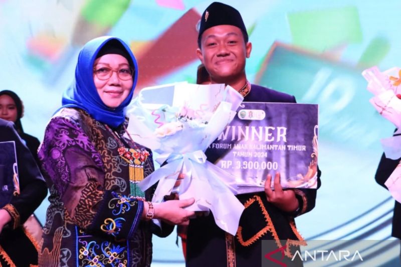 Kepala DKP3A Kaltim Noryani Sorayalita saat menyerahkan piagam penghargaan kepada Caesar Putra Dexan Pratama sebagai Duta Forum Anak Kaltim Tahun 2024. ( Diakominfo Kaltim).