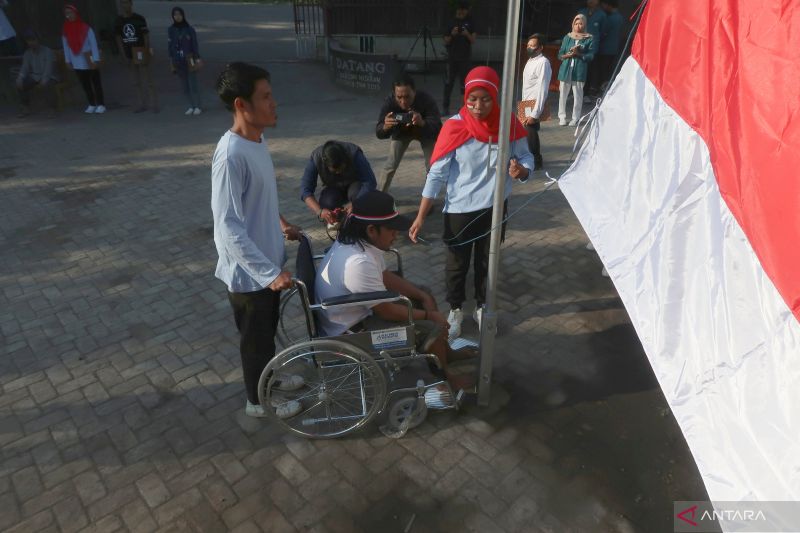 Penyandang disabilitas menjadi petugas pengibaran Bendera Merah Putih dalam rangka memperingati HUT ke-79 Kemerdekaan Republik Indonesia di Kantor Desa Taman Ayu, Kabupaten Lombok Barat, Nusa Tenggara Barat, Sabtu (17/8/2024). (ANTARA/Sugiharto Purnama)