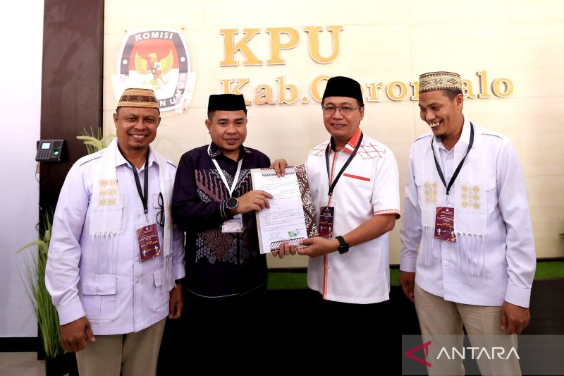 Ketua KPU Kabupaten Gorontalo Roy Hamrain (kedua kiri) berjabatan tangan dengan Ketua tim pemenangan Manaf Hamzah (kedua kanan) pada pendaftaran bakal calon Bupati dan Wakil Bupati pada Pemilihan Kepala Daerah (Pilkada) Kabupaten Gorontalo di kantor Komisi Pemilihan Umum (KPU) Kabupaten Gorontalo, Gorontalo, Selasa (27/8/2024). ANTARA/Adiwinata Solihin