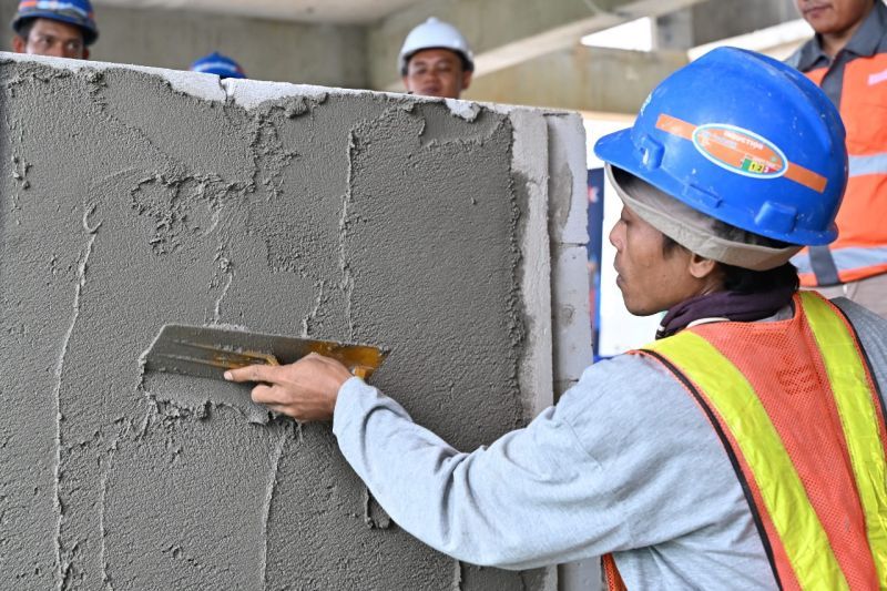 Tenaga konstruksi melakukan praktik mengerjakan plester dinding saat pelatihan dan sertifikasi tenaga konstruksi yang diselenggarakan SIG bersama Balai Jasa Konstruksi Wilayah (BJKW) V Banjarmasin di IKN. (ANTARA/HO-SIG)