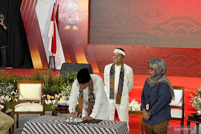 Pasangan Dedi Mulyadi dan Erwan Setiawan menandatangani berita acara penyerahan berkas pendaftaran mereka sebagai pasangan calon gubernur dan wakil gubernur Jabar yang disaksikan oleh Ketua KPU Jabar Ummi Wahyuni di Gedung Sate Bandung, Selasa (27/8/2024). (ANTARA/Ricky Prayoga)