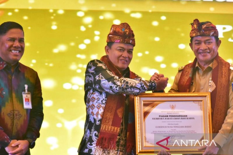 Kepala Badan Pembinaan Hukum Nasional (BPHN) Kemenkumham, Widodo Ekatjahjana menyerahkan piagam penghargaan Anubhawa Sasana Desa/Kelurahan kepada Penjabat Gubernur Nusa Tenggara Barat (NTB) Hassanudin saat peresmian 56 desa/kelurahan sadar hukum di Hotel Prime Park Kota Mataram, Selasa (27/8/2024). (ANTARA/Nur Imansyah).