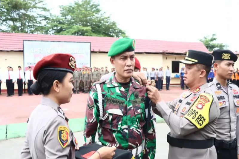 Kapolres Pasangkayu AKBP Candra Kurnia Setiawan (kanan) menyematkan pita tanda operasi kepada salah seorang personel TNI, pada apel gelar pasukan Operasi Mantap Praja 2024, di Pasangkayu, Selasa (27/8). (ANTARA/HO-Humas Polda Sulbar)