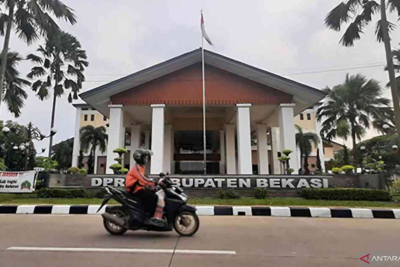 Pengendara melintasi gedung DPRD Kabupaten Bekasi, Jawa Barat di kompleks perkantoran Pemkab Bekasi, Desa Sukamahi, Kecamatan Cikarang Pusat. (ANTARA/Pradita Kurniawan Syah).