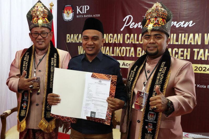 Ketua Komisi Independen Pemilihan (KIP) Banda Aceh Yusri Razali (tengah) memperlihatkan berkas pendaftaran pasangan bakal calon Wali Kota Zainal Arifin (kiri) dan bakal calon Wakil Wali Kota Banda Aceh Mulia Rahman (kanan) di Banda Aceh, Aceh, Selasa (27/8/2024). ANTARA FOTO/IRWANSYAH PUTRA