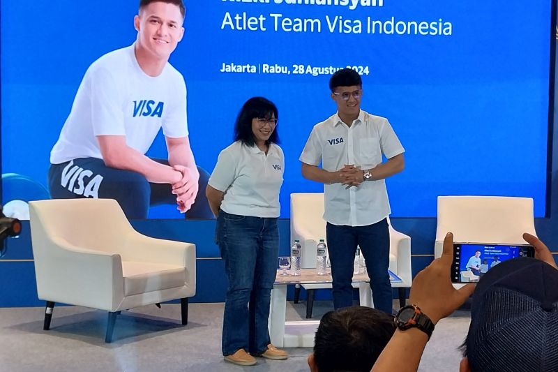 Atlet angkat besi (lifter) Riski Juniansyah (kanan) bersama Country Manager Visa Indonesia Vira Widiyasari berpose bersama dalam acara Meet & Greet Team Visa Athlete Rizki Juniansyah" di Jakarta, Rabu (28/8/2024). (ANTARA/Aloysius Lewokeda)