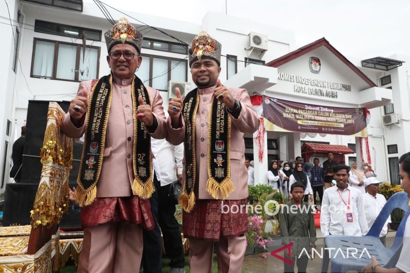 Pasangan calon Wali Kota dan Wakil Wali Kota Banda Aceh Zainal Arifin-Mulia mengenakan Kupiah Meukutop yang diserahkan KIP Banda Aceh sebagai adat Peumulia Jamee saat pendaftaran, di Banda Aceh, Selasa (27/8/2024) (ANTARA FOTO/Irwansyah Putra)