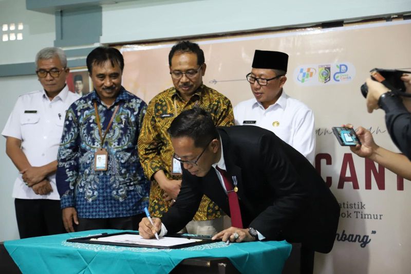 Penjabat Bupati Lombok Timur Juaini Taofik menandatangani piagam pencanangan Desa Cinta Statistik yang disaksikan langsung oleh Kepala BPS NTB Wahyudin (kedua kiri) di Mataram, Nusa Tenggara Barat, Rabu (28/8/2024). ANTARA/HO-Diskominfotik NTB
