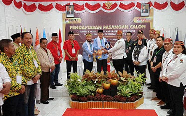 Pasangan Calon Bupati dan Wakil Bupati Barito Timur, M Yamin dan Adi Mula Nakalelu HA Garoe, menerima plakat dan maskot Pilkada Barito Timur dari Ketua KPU Satya Hedipuspita, usai menyelesaikan pendaftaran, Kamis, 29 Agustus 2024. (FOTO: BOLE MALO)