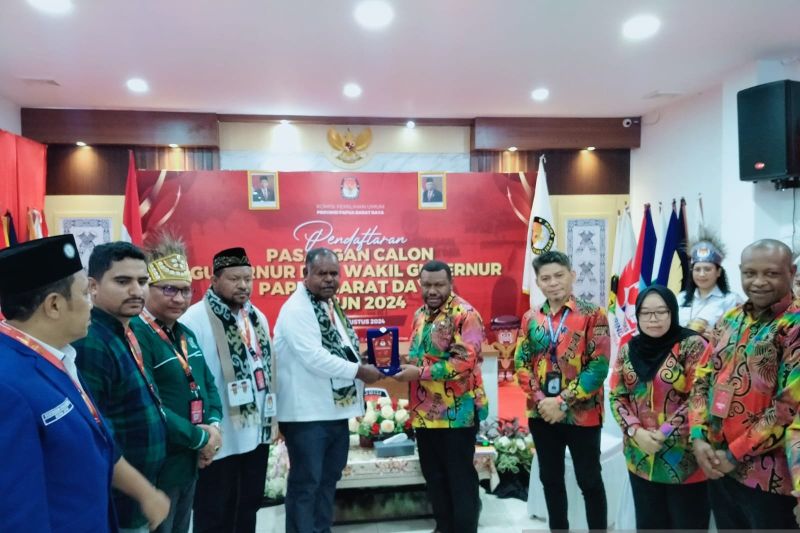 Pasangan calon Gubernur Papua Barat Daya Elisa Kambu dan Ahmad Nasrauw didampingi partai pendukung pose bersama Ketua KPU Andarias Kambu saat pengembalian berkas pendaftaran, Kamis (29/8/2024) (ANTARA/Yuvensius Lasa Banafanu)