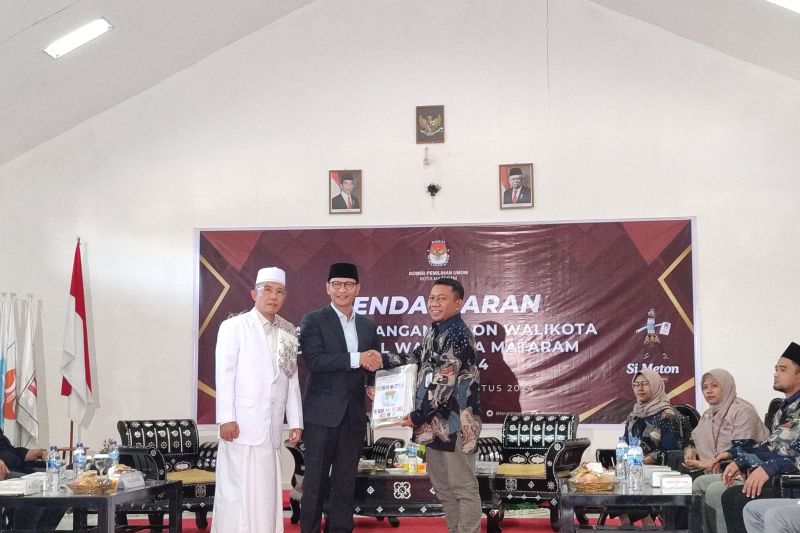 Pasangan bakal calon Wali Kota dan Wakil Wali Kota Mataram H Mohan Roliskana dan TGH Mujiburrahman atau paket "Harum" yang merupakan calon petahana menyerahkan dokumen pendaftaran ke Ketua Komisi Pemilihan Umum (KPU) Kota Mataram Edy Putrawan (kanan) di aula KPU Kota Mataram, Provinsi Nusa Tenggara Barat, Kamis (29/8-2024). (ANTARA/Nirkomala)