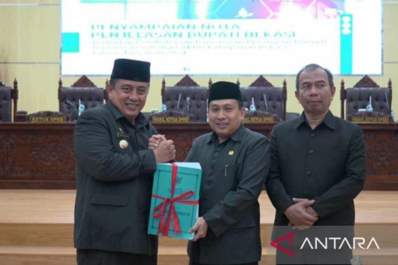 Penjabat Bupati Bekasi Dedy Supriyadi (kiri) menyerahkan nota Raperda Perubahan APBD Kabupaten Bekasi 2024 kepada Ketua DPRD BN Holik Qodratullah di Ruang Rapat Paripurna, Kamis. (ANTARA/Pradita Kurniawan Syah).