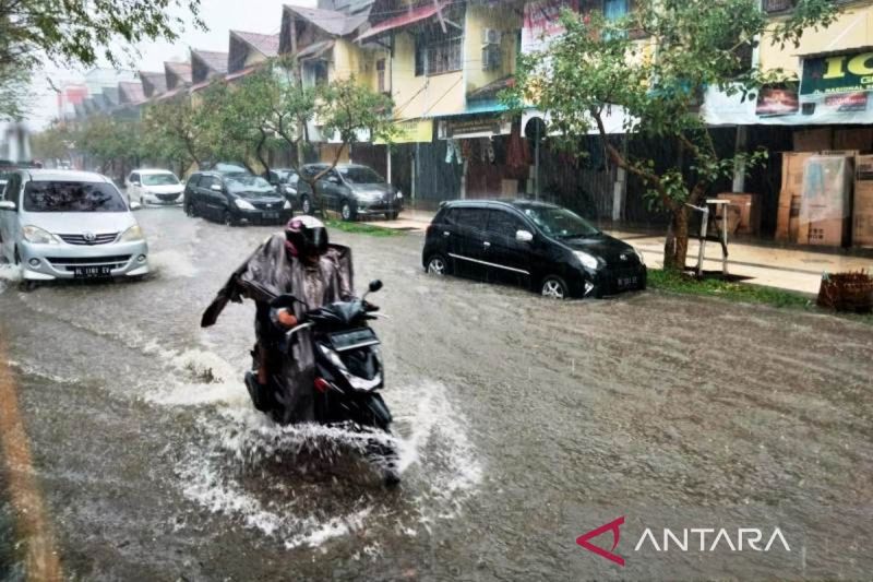 Sejumlah pengendara melintasi genangan air saat hujan di Meulaboh, Kabupaten Aceh Barat. (ANTARA/Teuku Dedi Iskandar)