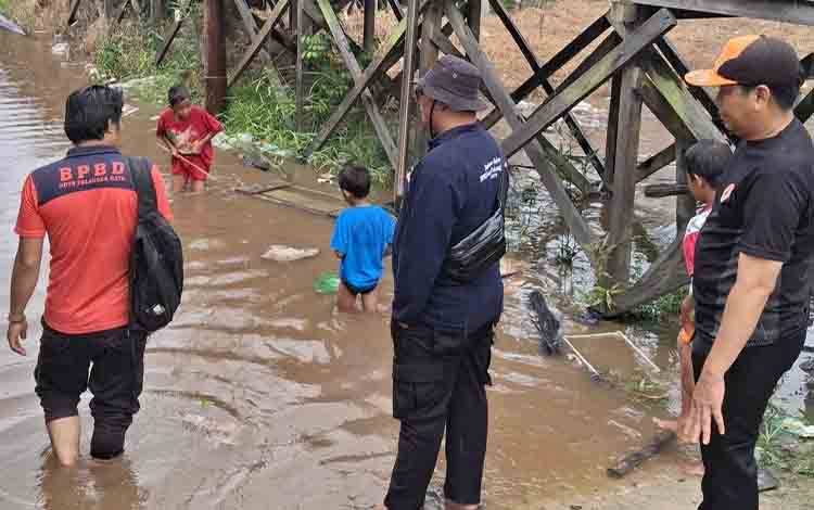 TRC BPBD Palangka Raya saat melakukan pengecekan debit air di Jalan Petuk Katimpun. (FOTO: TRC BPBD Palangka Raya)