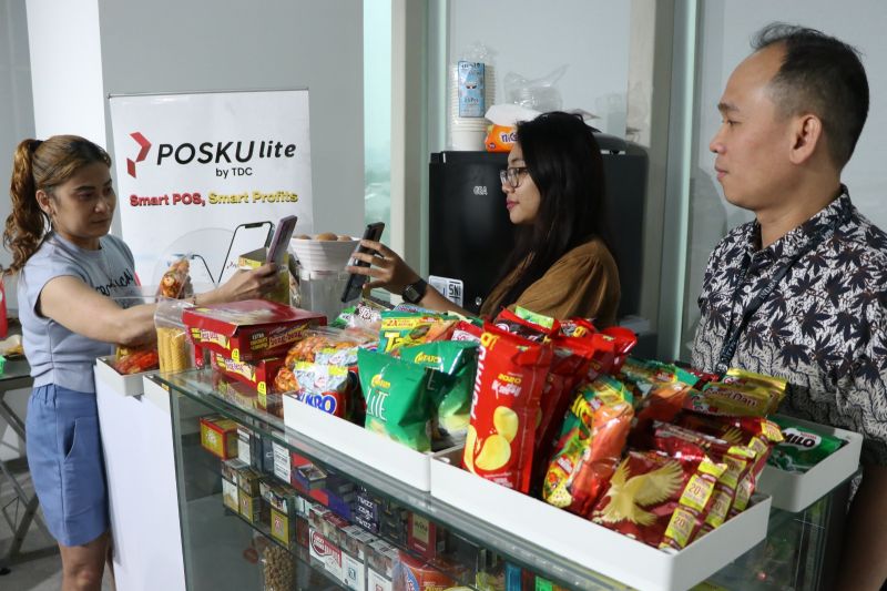 Praktisi ekonomi digital Indra (kanan), yang juga merupakan direktur utama penyedia teknologi digital PT Trans Digital Cemerlang (TDC), melihat sosialisasi platfom digital di salah satu warung di daerah Jakarta. ANTARA/HO-PT TDC.