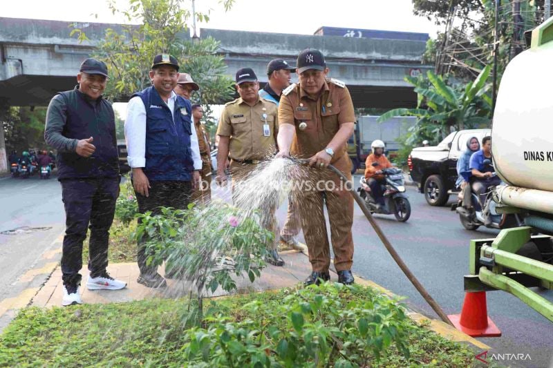 Penjabat Bupati Bekasi Dedy Supriyadi menyiram tanaman di taman median Jalan Inspeksi Kalimalang, Desa Cibatu, Kecamatan Cikarang Selatan, Selasa. (ANTARA/Pradita Kurniawan Syah).