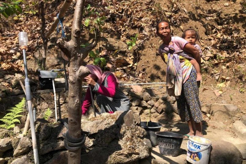 Warga mengambil air dingin sumber air yang ada di tengah hutan, Trenggalek, Selasa. (ANTARA/HO - Prastyo)