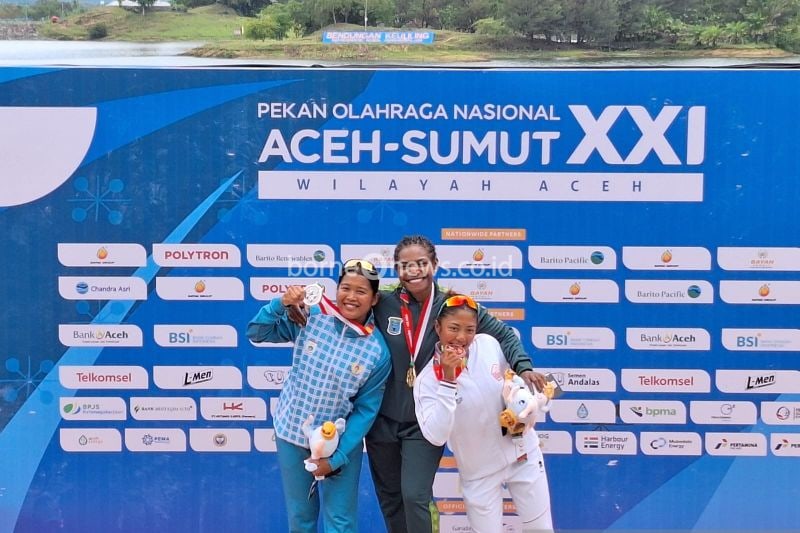 Pedayung Sulawesi Barat, Ramla B (kiri) bersama dengan pedayung Papua Pegunungan, Stevani Maysche Ibo (tengah) dan pedayung Jakarta, Cinta Priendtisca Nayomi (kanan) memamerkan medali canoeing nomor kayak 1000 m putri PON Aceh-Sumut 2024 di Waduk Keuliling, Aceh Besar, Rabu (4/9/2024). (ANTARA/FAJAR SATRIYO)