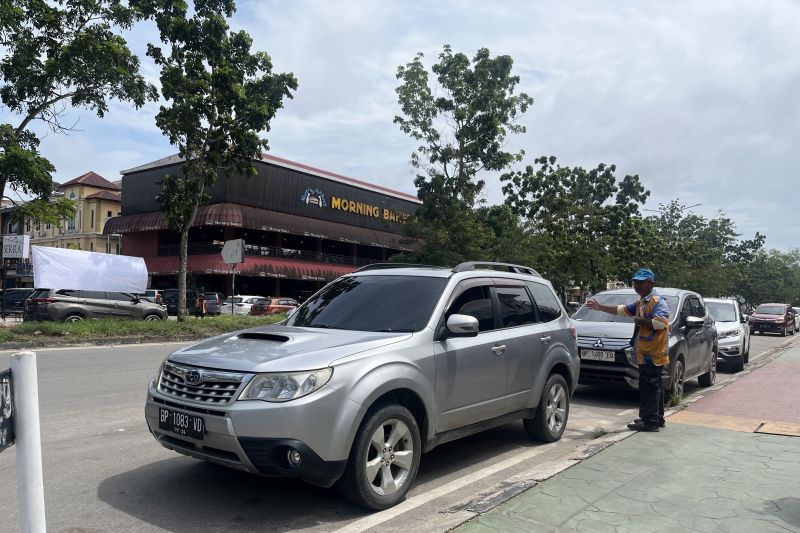 Seorang juru parkir (jukir) di Batam saat membantu pengendara memarkirkan kendaraan. (ANTARA/Jessica)