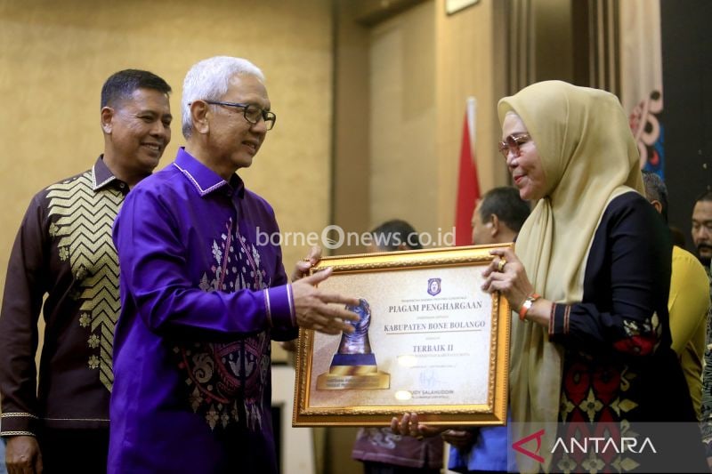 Pj Gubernur Gorontalo Rudy Salahuddin (tengah) disaksikan Direktur Utama BPJS Ketenagakerjaan (BPJamsostek) Anggoro Eko Cahyo (kiri) menyerahkan penghargaan kepada Bupati Bone Bolango Merlan Uloli (kanan) pada Paritrana Award tahun 2023 di Kota Gorontalo, Gorontalo, Selasa (3/9/2024). ANTARA Adiwinata Solihin