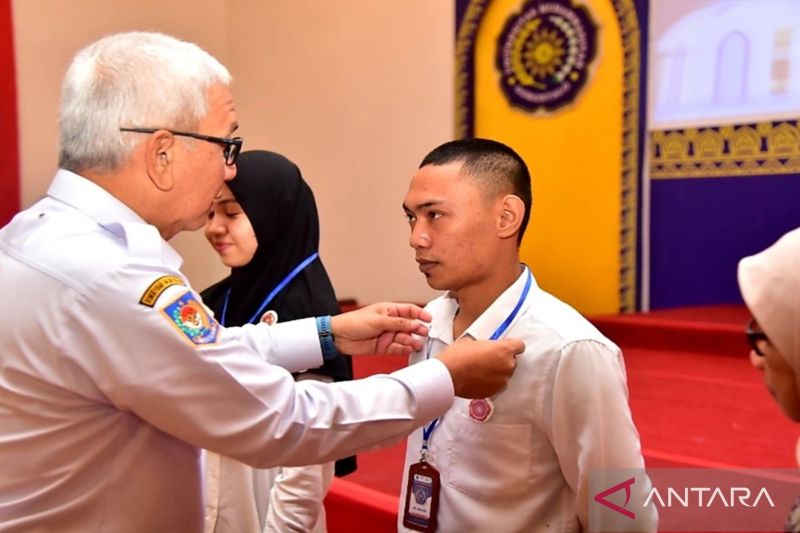 Penjabat Gubernur Gorontalo Rudy Salahuddin saat menyematkan tanda pengenal mahasiswa baru Universitas Muhammadiyah Gorontalo (UMGO) yang akan mengikuti kegiatan Pengenalan Studi Mahasiswa Baru (Pesmaba) UMGO Tahun Akademik 2024 hingga 2025, di Gedung Indoor DBA UMGO Kabupaten Gorontalo. ANTARA/HO-Diskominfotik Provinsi Gorontalo