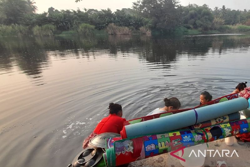 Warga sekitar sedang mencuci di sungai ciujung yang menghitam, di Desa Masigit, Kecamatan Carenang, Kabupaten Serang, Kamis (5/9/2024). ANTARA/Desi Purnama Sari
