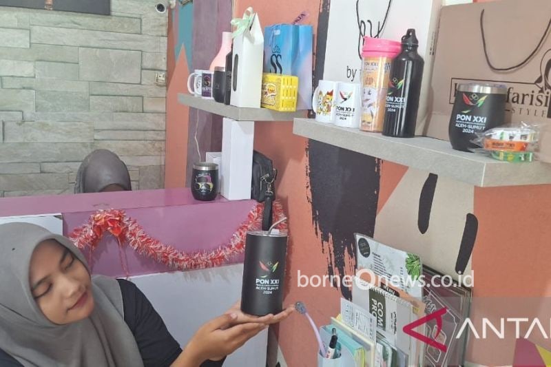 Salah seorang pekerja di usaha digital printing sedang memperlihatkan pernak-pernik PON Aceh-Sumut (ANTARA/M Ifdhal)