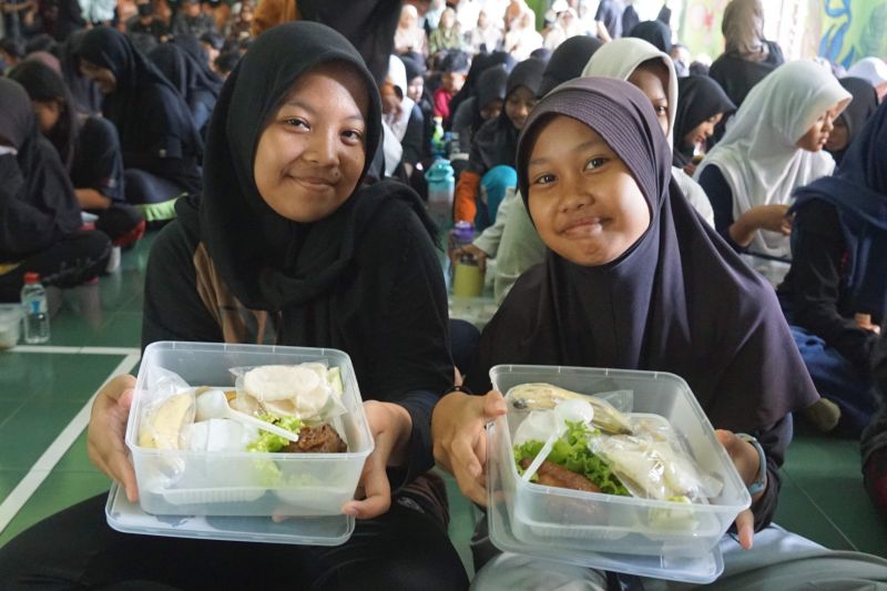 Para murid SMPN 12 Kota Yogyakarta menunjukan menu makan bergizi seimbang saat sarapan bersama Gerakan Aksi Bergizi, Jumat (6/9/2024). (ANTARA/HO-Pemkot Yogyakarta)