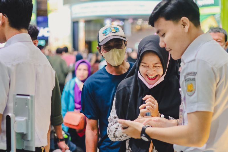 Petugas membantu penumpang untuk melakukan check-in di Stasiun Gambir, Jakarta. ANTARA/HO-KAI Daop 1 Jakarta.