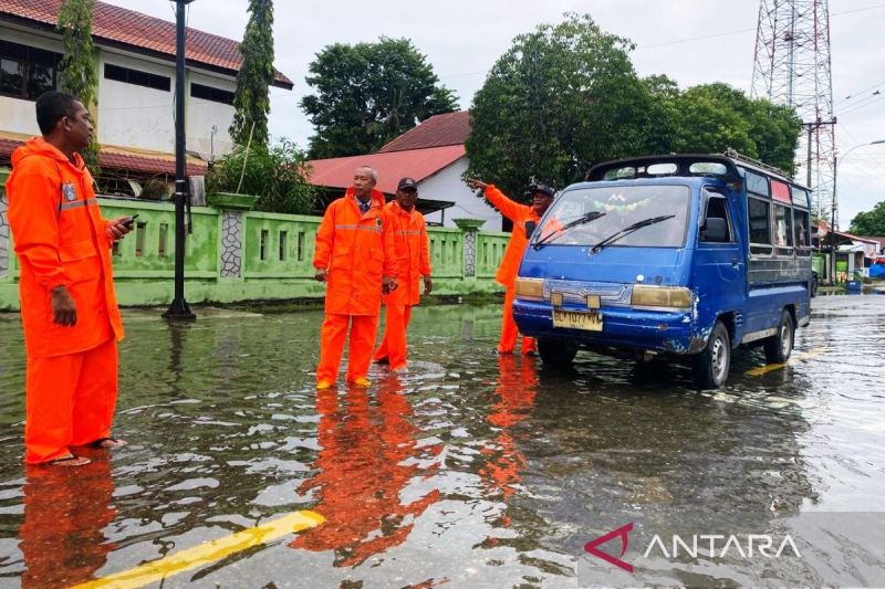 Personel Dinas Perhubungan Kabupaten Aceh Barat, mengatur lalu-lintas di lokasi banjir menuju ke arena Lapangan Sofbol PON Aceh-Sumut 2024 di ruas Jalan Merdeka, Meulaboh, ibu kota kabupaten setempat, Sabtu (7/9/2024). (ANTARA/Teuku Dedi Iskandar)