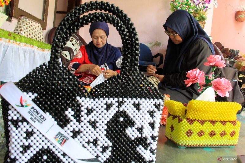 Perajin menyelesaikan pembuatan kotak tisu bertema PON XXI Aceh-Sumut di rumah Handycarf, Medan, Sumatera Utara, Rabu (4/9/2024). Menurut perajin, berbagai kerajinan berbahan akrilik seperti kotak tisu, vas bunga, dan kotak permen tersebut dijual seharga Rp15 ribu hngga Rp450 ribu tergantung bahan dan model. ANTARA FOTO/Yudi Manar/tom