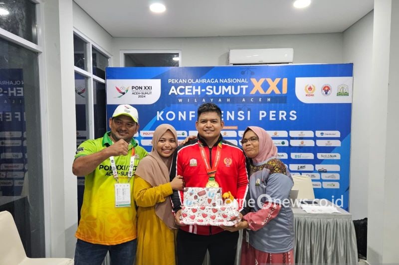 Lifter Aceh, Muhammad Zul Ilmi (kedua dari kanan) berfoto bersama keluarganya setelah tampil pada pertandingan angkat besi kelas 89 kilogram putra Pekan Olahraga Nasional (PON) Aceh-Sumatera Utara 2024, di GOR Seramoe, Banda Aceh, Sabtu (7/9/2024). (ANTARA/RAUF ADIPATI)
