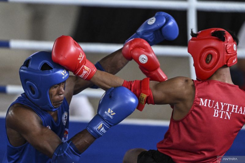 Atlet muaythai Banten Sandi Hidayat (kanan) melepaskan pukulan ke altlet muaythai Jawa Barat Gusti Sialana (kiri) pada babak perempat final kelas 71 kg putra PON XXI Aceh-Sumut 2024 di Gedung Balai Meuseuraya Aceh, Banda Aceh, Aceh, Sabtu (7/9/2024). . ANTARA FOTO/Aprillio Akbar/aww.